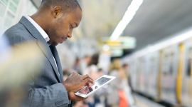 man waiting in subway with tablet