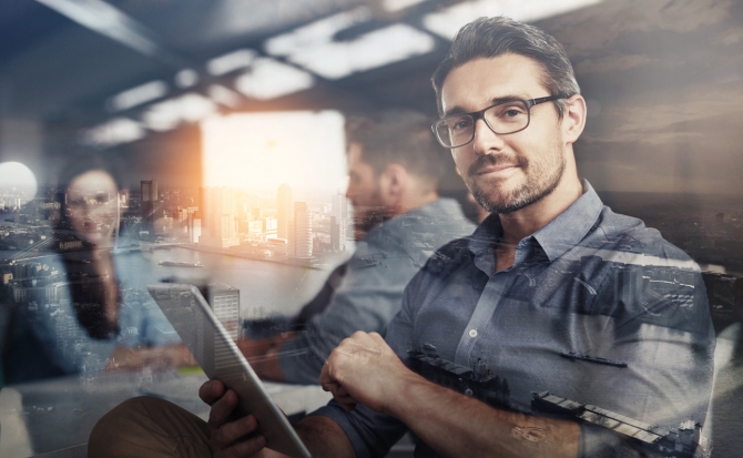 Man smiling while holding digital tablet