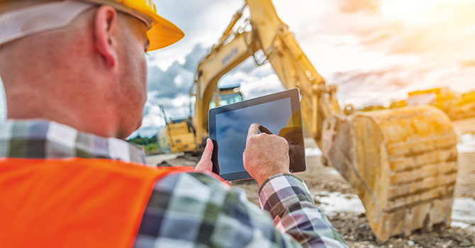 man using tablet at construction
