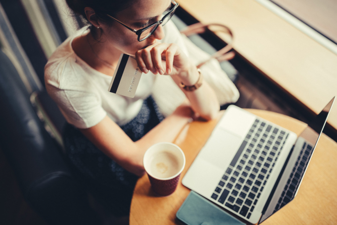 Female using laptop and holding a credit card