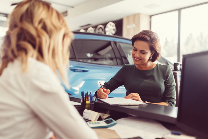 woman signing a car contract