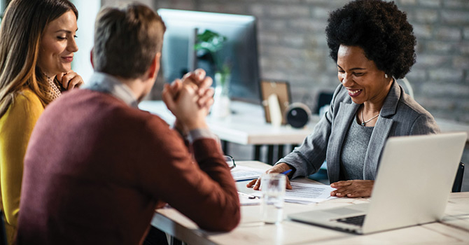 Young couple talking to a businesswoman