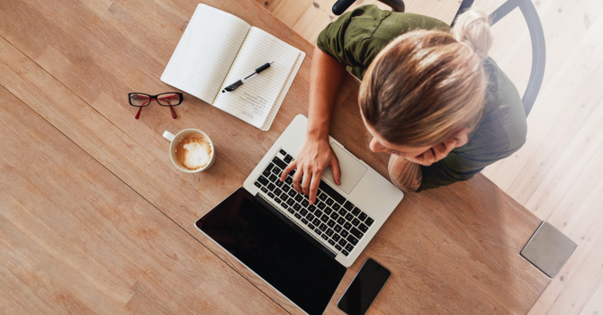 woman sitting on table with laptop