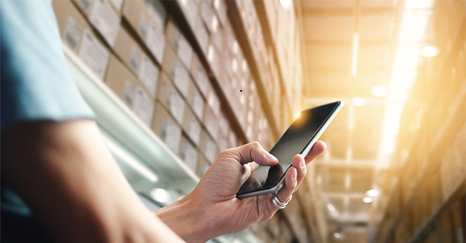 man with smartphone in warehouse