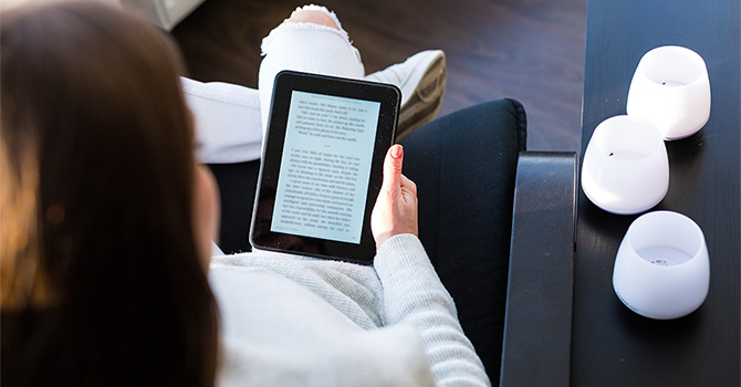 Sitting woman, holding an e-book reader