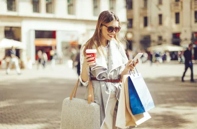 Woman checking phone after shopping