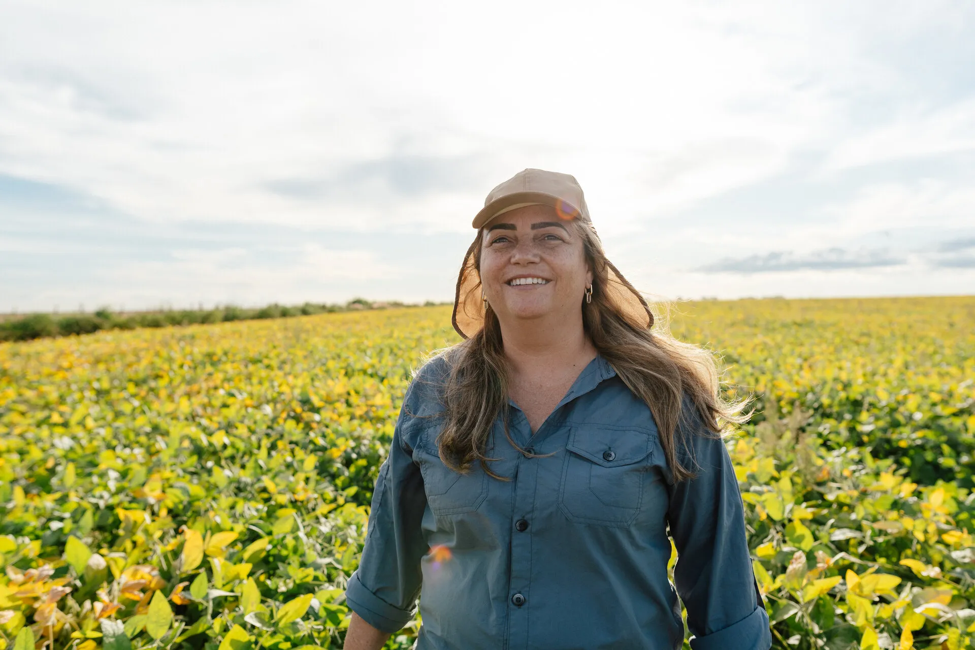 Confident and happy female agronomist in yellowing soybean plantation