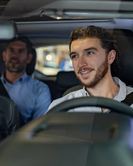 Ride share driver chatting enthusiastically with passenger
